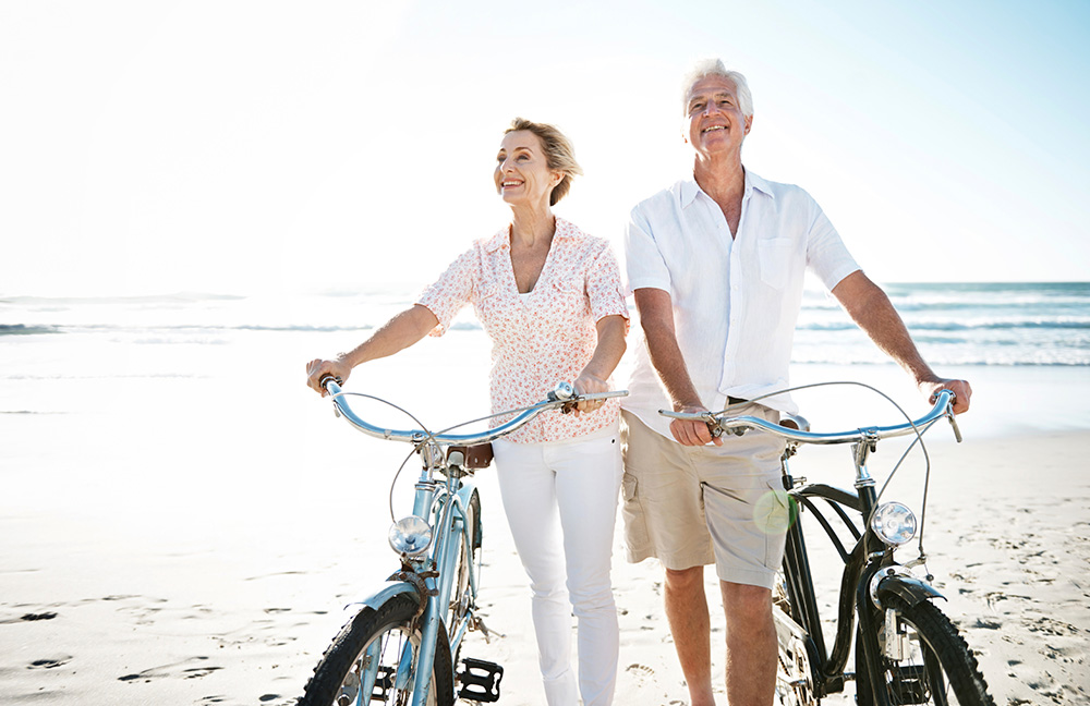 older couple at beach with bicycles